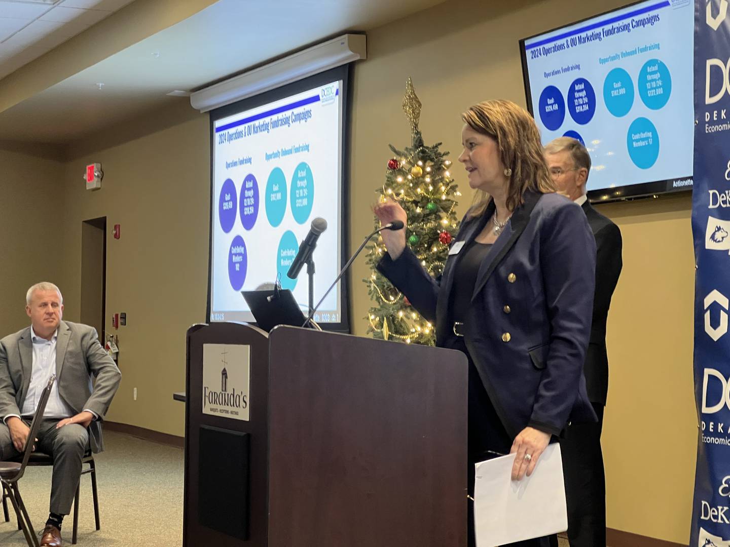 DeKalb Mayor Cohen Barnes and former DeKalb County Economic Development Corporation executive board president Michael Kokott on Dec. 13, 2024 listned as the corporation's executive director Melissa Amedeo addressed a crowd of over 100 in Farranda's Banquets Hall.