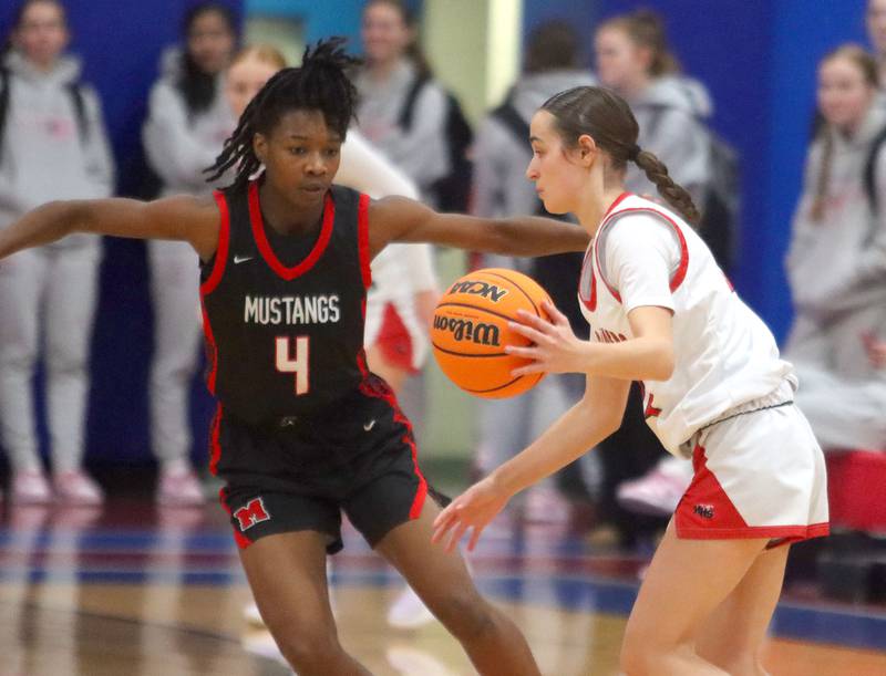 Huntley’s Kara Giordano, right, moves the ball as Mundelein’s Grace Dunigan defends in varsity girls basketball Komaromy Classic tournament  action on Tuesday, Dec. 30, 2025, at Dundee-Crown High School in Carpentersville.