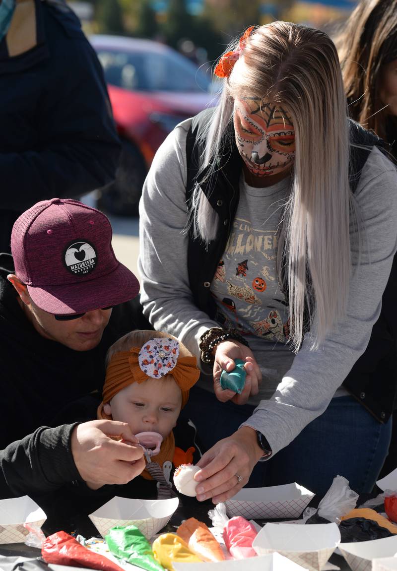 Children and families including (left-right) Christie, Ellyette and Tricia Cantaliena of Downers Grove make sugar skulls during the Day of the Dead event held at Brookfield Zoo Friday Oct 29, 2022.