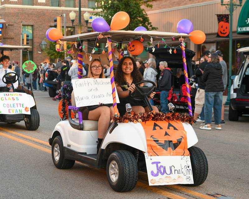 Sycamore students and Homecoming candidates (from right) Faith Michael, and Maria Chiara Anti of the Journalism Club, drive in the Homecoming parade on Wednesday, Oct. 8, 2025, downtown.
