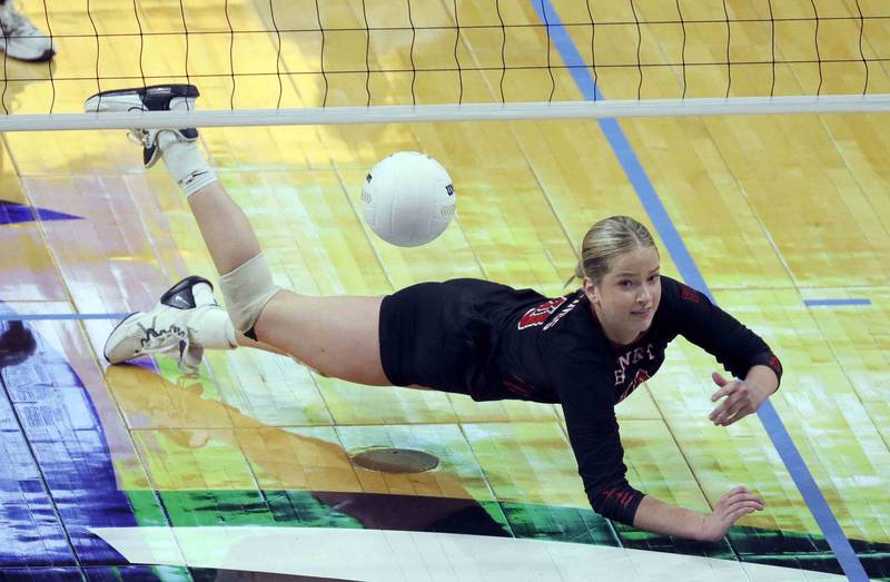 Benet’s Ava Novak (10) dives for a save during the IHSA Class 4A girls volleyball state title game between Benet Academy and Mother McAuley Saturday November 12, 2022 at Redbird Arena in Normal.