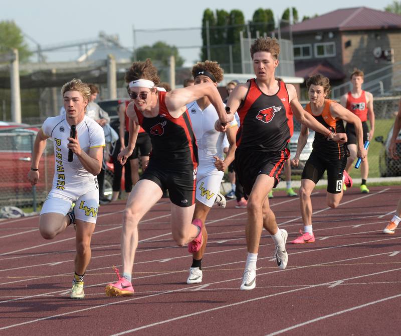 Forreston-Polo's Michael Taylor takes the baton from Noah Dewey on the last exchange of the 4 x100 at the 1A Rockridge Sectional on Friday, May 19.