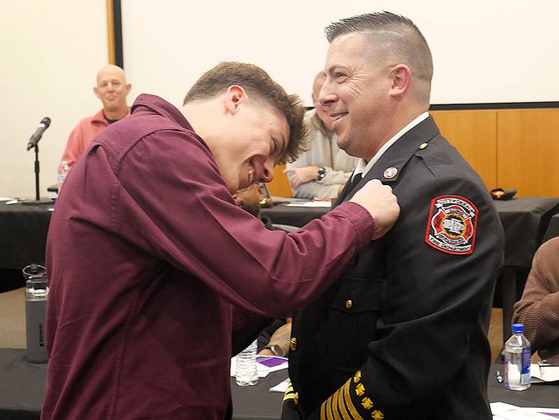 DeKalb Fire Chief Luke Howieson laughs with his son, Luke, during a swearing-in ceremony on Monday, Jan. 12, 2026, at the DeKalb Public Library.