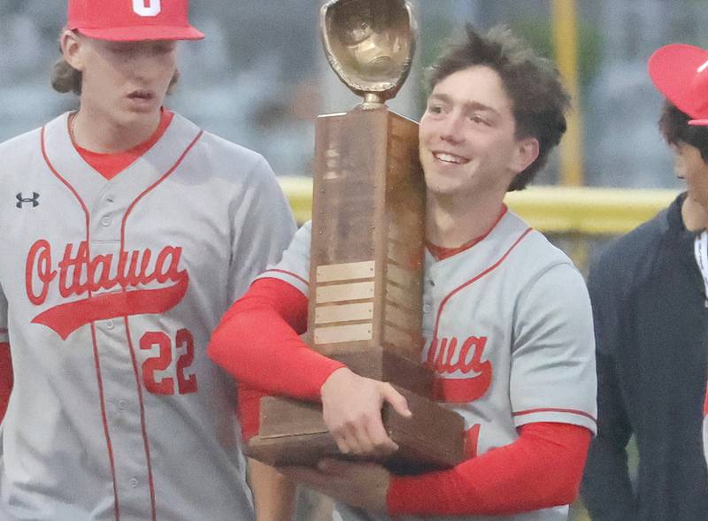 Ottawa's Adam Swanson hugs the Illinois River Rivalry trophy after defeating L-P on Thursday, April 30, 2026 at Huby Sarver Field in the L-P Athletic Complex in La Salle.