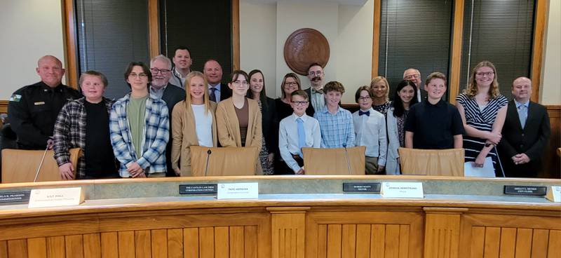 Members of the Ottawa City Government pause with the Marquette Academy and Ottawa Shepherd Middle School students who assumed their civic roles for the city council meeting on Tuesday.