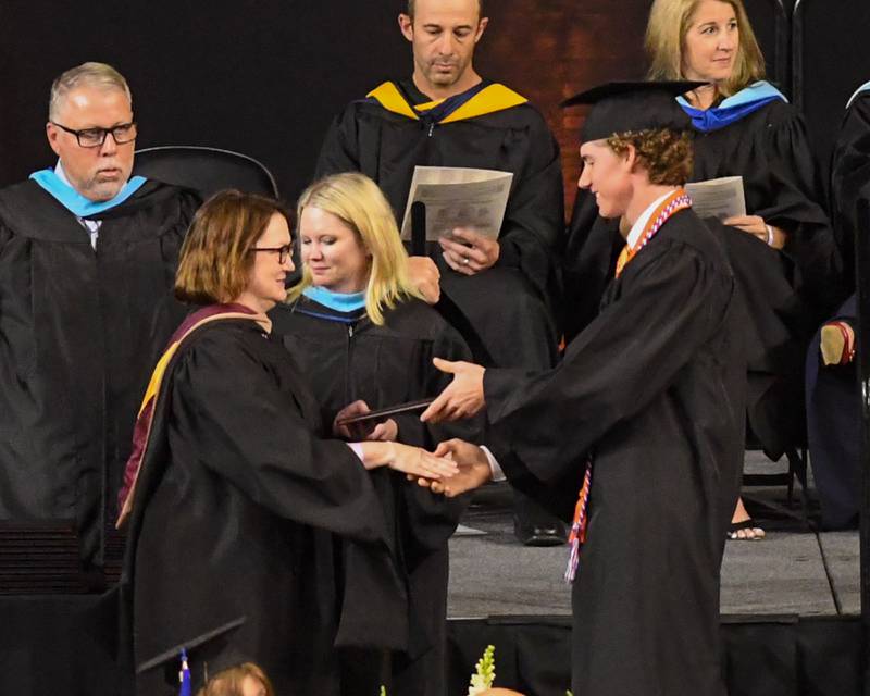 A St. Charles East graduate accepts his diploma on Monday, May 18, 2026, at the Convocation Center in DeKalb.
