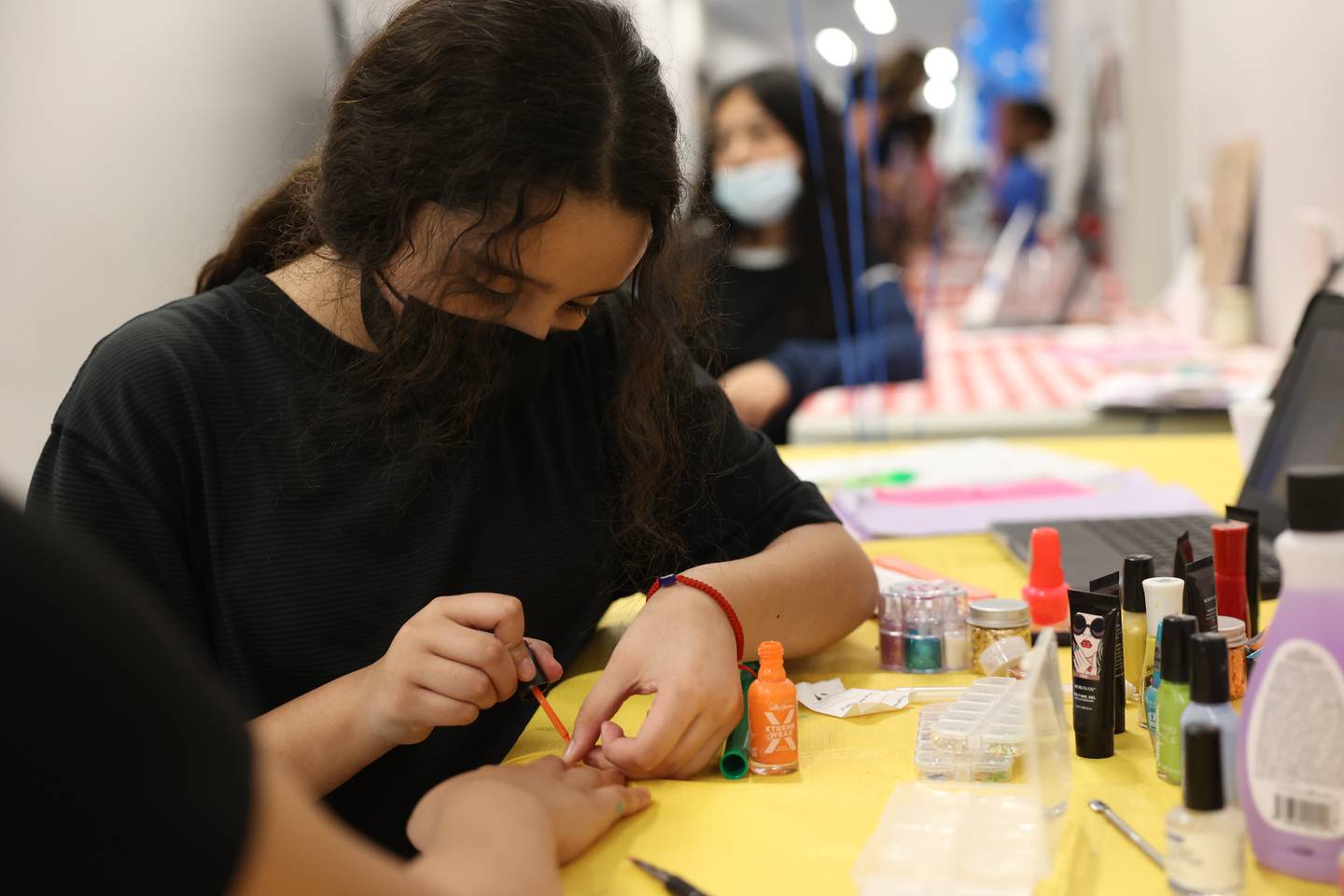 Betsy Contreras paints the nails of her business partner Alyssa Spinks at their AB Magic of Betsy and Alyssa Nail Salon at the Laraway 70C 5th Grade Business Expo. Friday, May 13, 2022, in Joliet.