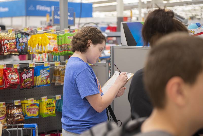 Angela Garcia jots down notes while checking out Thursday, May 19, 2022.