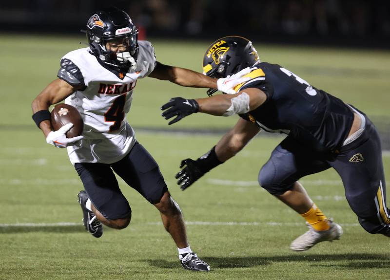 DeKalb's Xavier Dandridge tries to break the tackle of Metea Valley's Hani Omar during their game Friday, Sept 15, 2023, at Metea Valley High School in Aurora.