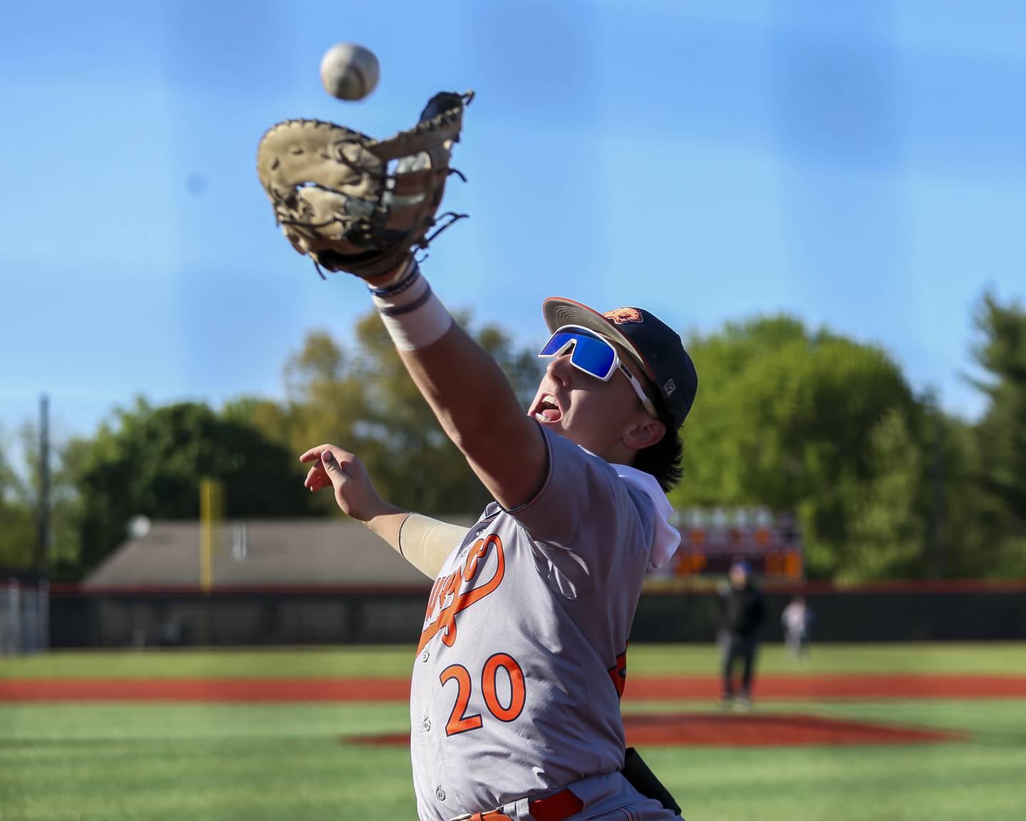 Oswego's Dylan King (20) slides in to catch a pop foul on the first base side during baseball game between Oswego at Yorkville. Thursday, May 8, 2025 in Yorkville.