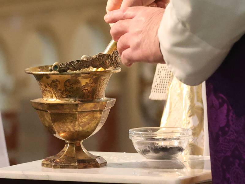 A priest prepares the chalice to distribute during Ash Wednesday Mass on Wednesday, Feb. 18, 2026 atThe Queen of the Holy Rosary Memorial Shrine in La Salle. Ash Wednesday marks the beginning of Lent eading up to observances of Jesus' death on Good Friday and resurrection on Easter.
