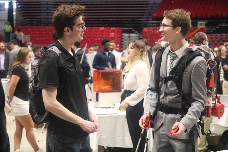 Stefan Mayer (right) offers a demonstration of his senior engineering project to Nathan McCleery (left) during an  engineering showcase held May 5, 2023 at the NIU Convocation Center in DeKalb.