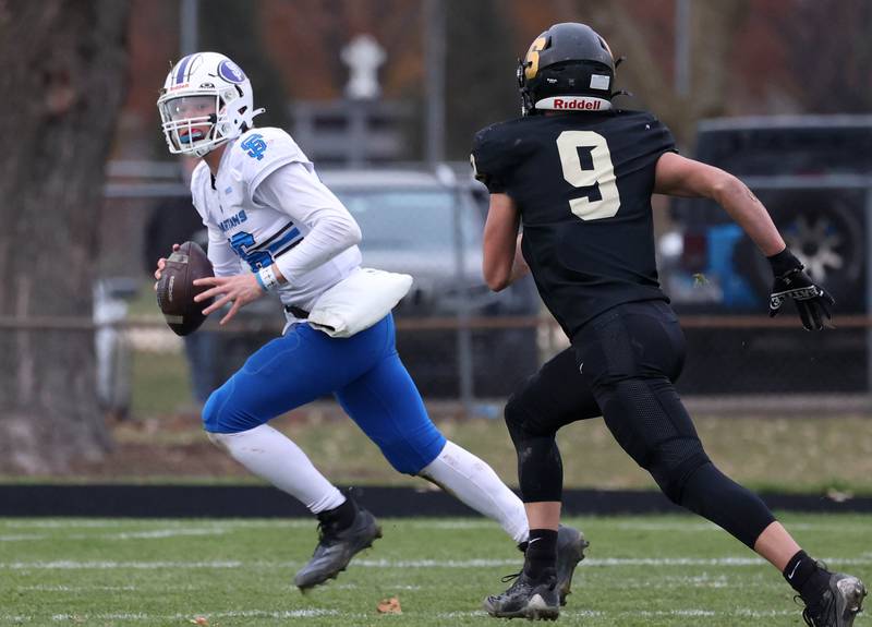 St. Francis' Brady Palmer rolls away from the rush of Sycamore's Caden O’Donnell Saturday, Nov. 16, 2024, during their Class 5A quarterfinal game at Sycamore High School.
