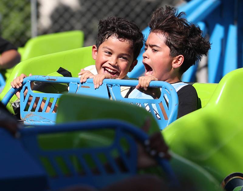 Damian Hernandez, (left) 7, and Jonathan Martinez, 10, from DeKalb, enjoy a ride at the carnival Friday, Aug. 22, 2025, during the first day of Corn Fest in downtown DeKalb.