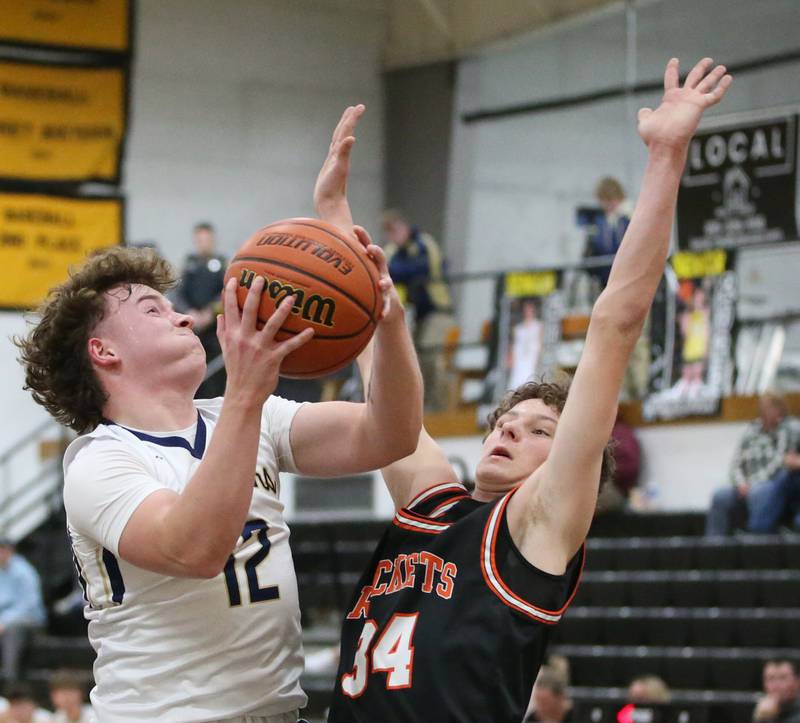 Marquette's Krew Bond plows through the lane to shoot a shot over Roanoke-Benson's Kaden Harms during the Tri-County Conference Tournament on Wednesday, Jan. 25, 2023 at Putnam County High School.