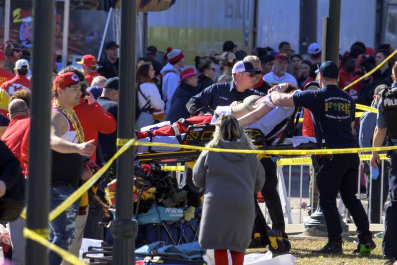 A woman is rushed to an ambulance following a shooting at the Kansas City Chiefs NFL football Super Bowl celebration in Kansas City, Mo., Wednesday, Feb. 14, 2024. Multiple people were injured, a fire official said.