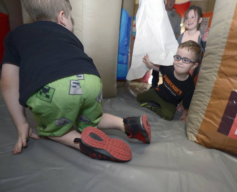 Children crawl through a make believe house fire to safety in the Ottawa Fire Department’s Fire Safety House Saturday at the Ottawa Y during Healthy Kids Day