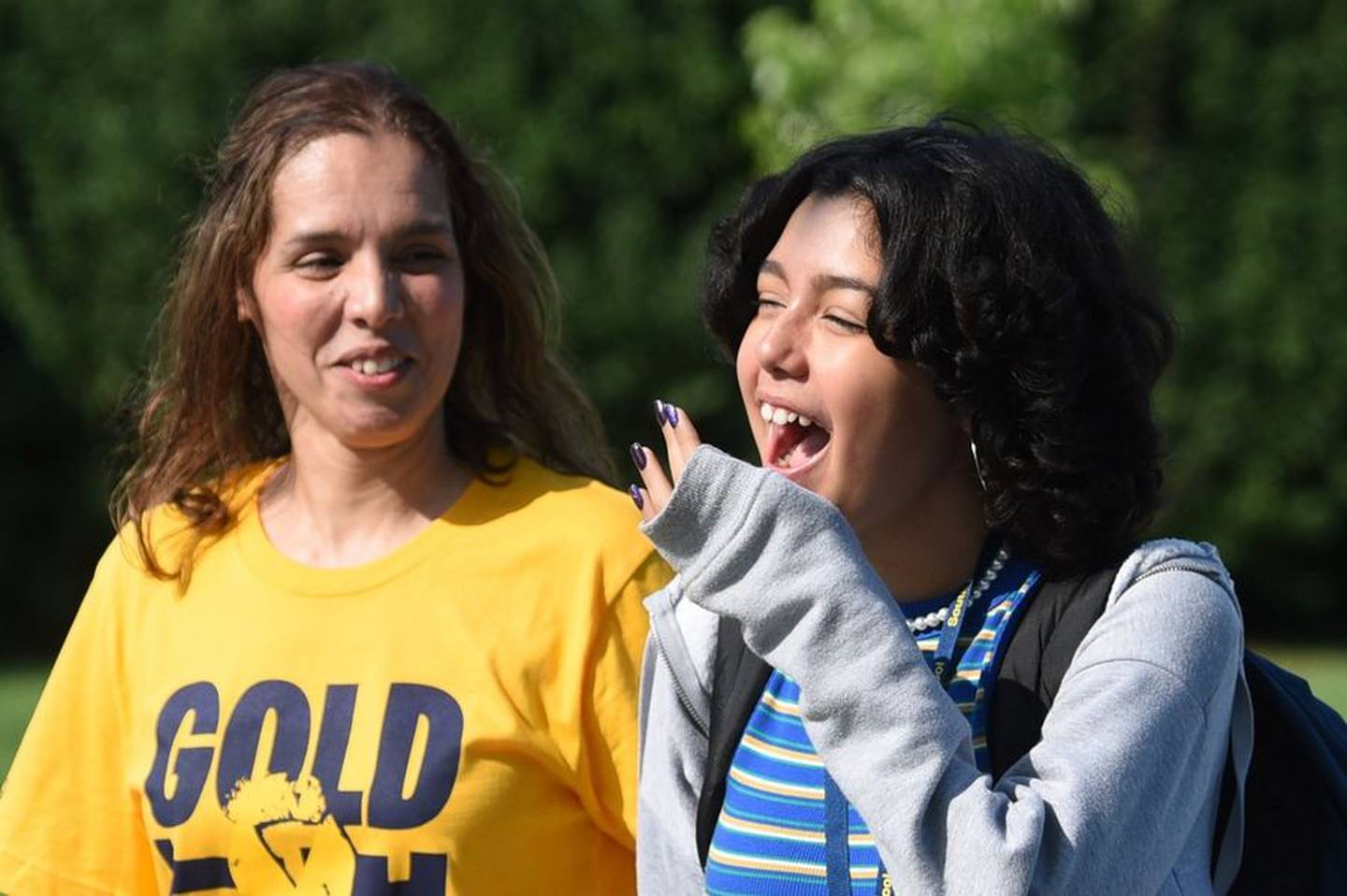 Cancer patient Kaylah Gonzalez of South Elgin bursts out laughing when she sees the mob of people on her front lawn Wednesday as she gets home from school. Representatives from the Chicago Bears and Advocate Aurora Health gave her family an all-expenses-paid trip to see the Bears play in Green Bay this Sunday.