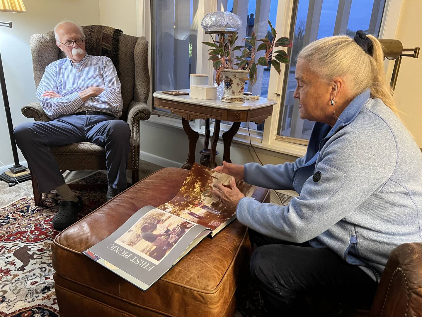 Larry Berke watches as Kay Berke shows a book full of family photos.