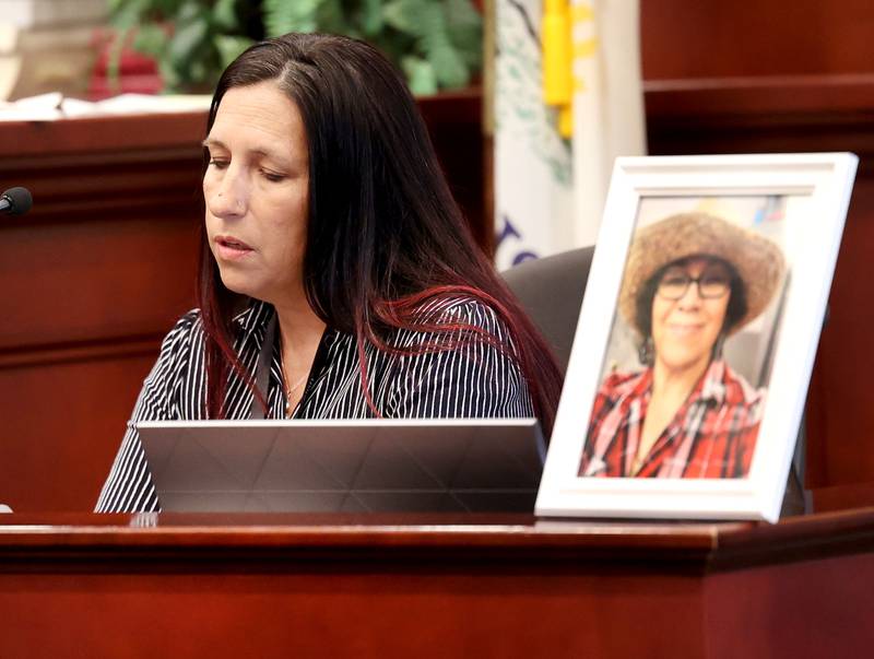 Carrie Kirkpatrick, a victim advocate with Alliance Against Intoxicated Motorists, reads an impact statement on behalf of Flor Reyes, the daughter of Graciela Reza Contreras, in the framed photo, during the sentencing hearing for Former police officer James Corralejo Thursday, July 17, 2025, at the DeKalb County Courthouse in Sycamore. Corralejo was sentenced to four years in prison for a Class 2 felony count of driving under the influence of alcohol causing death for a 2023 crash that killed Reza Contreras.