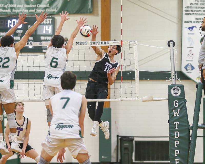 Downers Grove North's Aidan Akkawi (11) smashes the ball over the net for a kill during volleyball match between Downers Grove North at Glenbard West.  April 2, 2024.