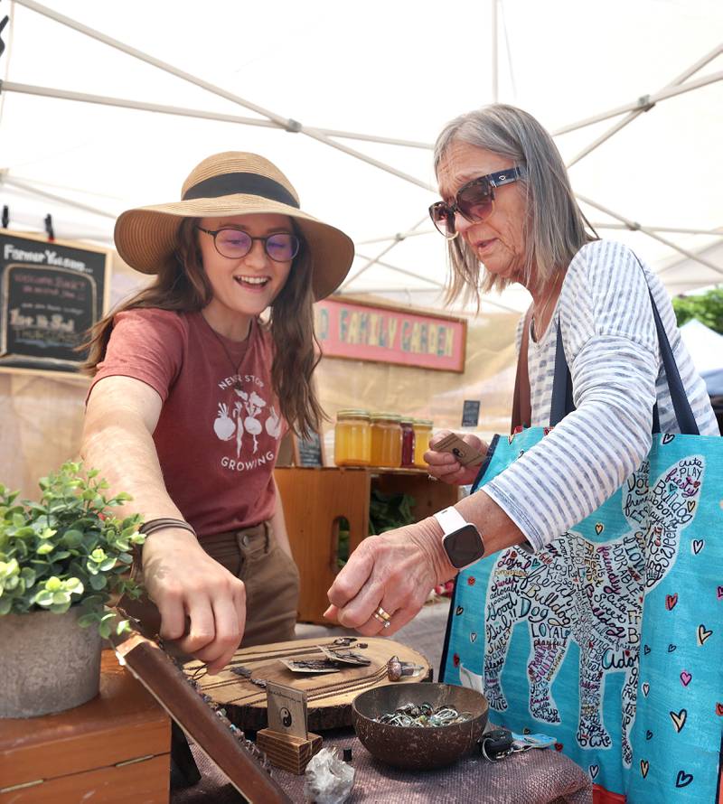 Jen Gontarek, (left) from Genoa, owner of Gratefully Dreaming, talks to Mary Hamell, of DeKalb, about birthstone rings she is selling at her booth Thursday, June 2, 2022, during the first DeKalb Farmers Market of the season at Van Buer Plaza in Downtown DeKalb.