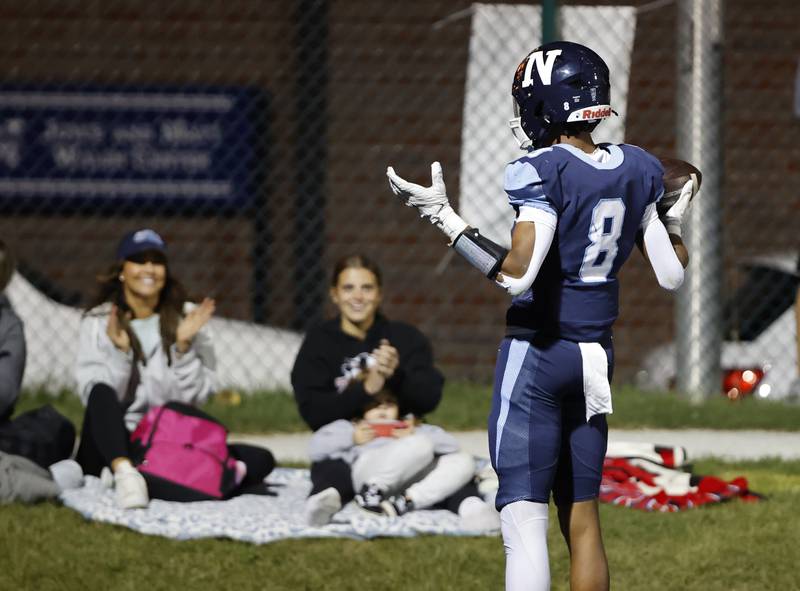 Nazareth's Trenton Walker (8) celebrates a touchdown in front of some fans during the varsity football game between Joliet Catholic and Nazareth academies on Friday, Sep. 27, 2024 in La Grange Park.