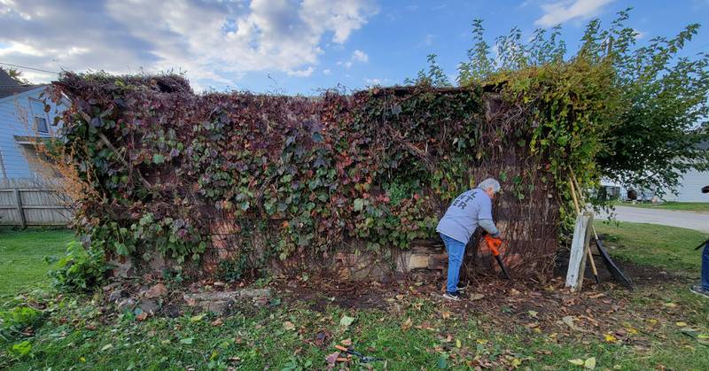 DeeDee Ulses Underwood uses a leaf blower to clean away debris from a garage during Saturday's Labor of Love projects.