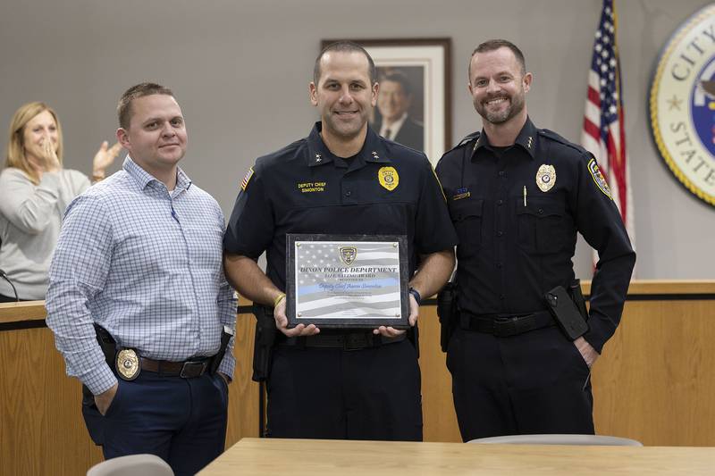 Dixon Police Sergeant Chris Scott (left) and Chief Ryan Bivins present Deputy Chief Aaron Simonton (middle) with the Life Saving Award Monday, Nov. 3, 2025, at the Dixon City Council meeting.
