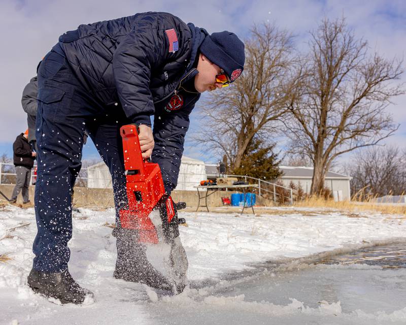 Ottawa Firefighter Brady Mitchell uses an electric saw to cut pieces of ice off and open up the escape route for divers at the Make-A-Wish Illinois Penguin Plunge on  January 31, 2026 at Skydive Chicago.