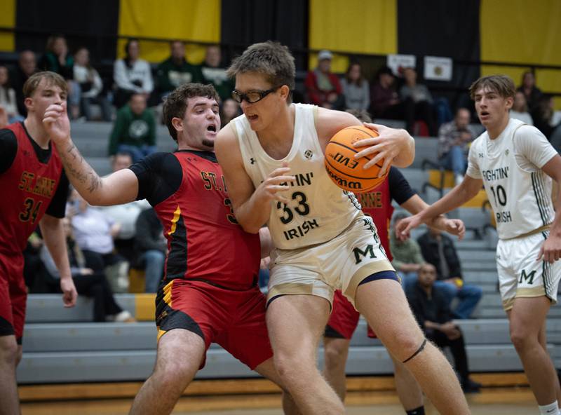 St. Anne's Brandon Schoth, left, takes a fall as Bishop McNamara's Callaghan O'Connor, center, works the ball toward the net in a game on Wednesday, November 26, 2025.