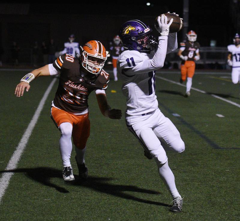 Rolling Meadows’ Arman Lepuzanovic catches a pass for a Mustangs touchdown against Hersey defender Luke Kolclanis during a football game on Friday, Oct. 18, 2024 in Arlington Heights.