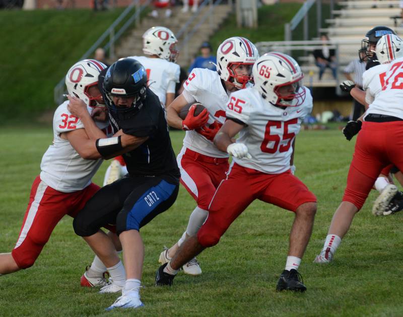 Oregon's Cooper Johnson (2) runs with the ball as Edward Gomez (65) and Jakob Moser (32) block during a practice game with Eastland-Pearl City on Friday, Aug. 22, 2025 at Lanark. The Hawks open the 2025 season at Genoa-Kingston on Friday, Aug. 29.