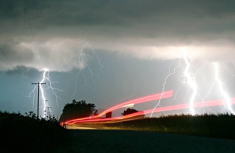 Brake lights from a pickup truck heading westbound on Owens Road near the intersection of Somonauk and Owens Roads in Pierce Township can be seen as lightning strikes during a thunderstorm on Wednesday, July 18, 2012.