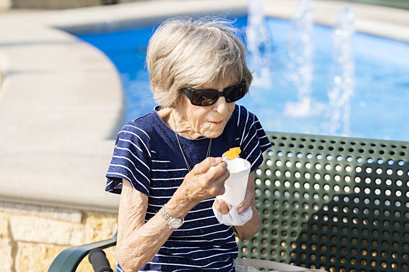 Jennifer Yaeger of Dixon digs into an orange cream icy treat Wednesday, June 21, 2023. Visitors to the Dixon City Market found ways to stay cool in a variety of ways.
