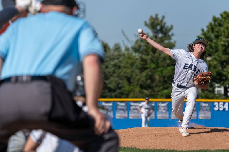 Oswego East's Bode Bregar (18) delivers a pitch against Oswego during a baseball game at Oswego East High School on Wednesday, May 10, 2023.