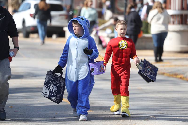 John Repsis, 11-years old, left, walks walks with his brother William, 8-years old, along West Lockport Street at the annual Halloween Spooktacular in downtown Plainfield on Saturday, Oct. 28, 2023.