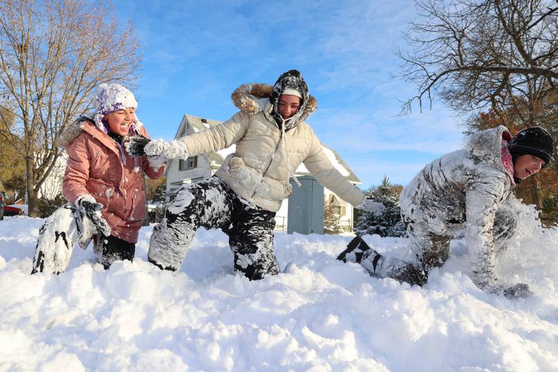 Siblings Kennedi Connor, 16, center, Eric Connor, 15, right, and Leah Pippin, all of Momence, enjoy their snow day home from school after approximately 12 inches of snow fell in the early hours of Nov. 10, 2025, in Momence.
