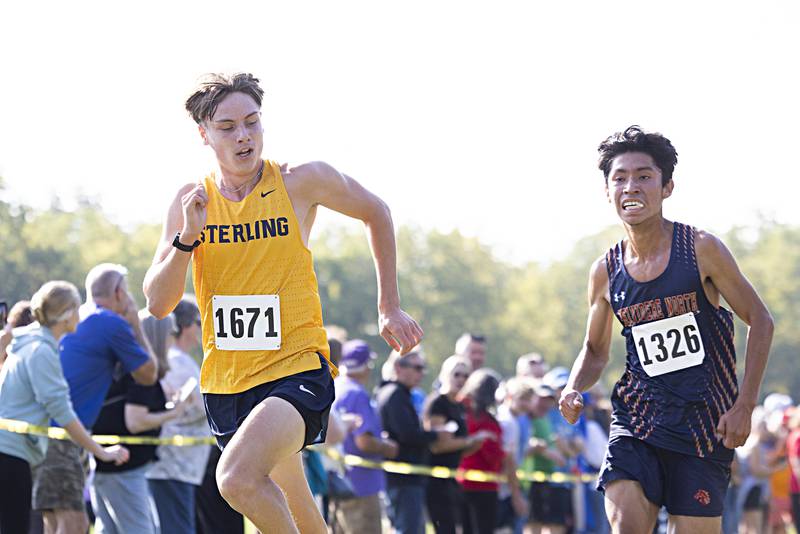 Sterling’s Parker Janssen looks back at competitor Anthony Avila near the finish at the Rock River Run race Saturday, Sept. 23, 2023 at Hoover Park in Sterling.
