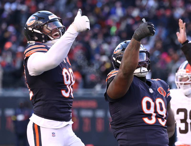 Chicago Bears defensive end Montez Sweat (left) and defensive tackle Gervon Dexter Sr.  celebrate after a sack of Cleveland Browns quarterback Shedeur Sanders during their game Sunday, Dec. 14, 2025, at Soldier Field in Chicago.
