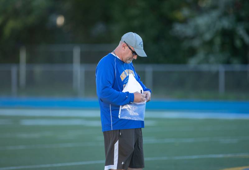 Head Coach Joe Wardynski writes notes during practice at Wheaton North High School on Thursday, Aug. 11, 2022.