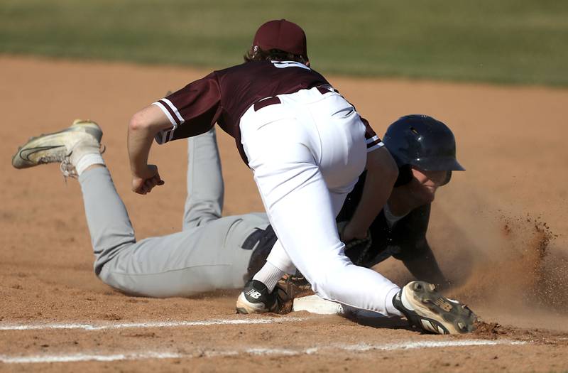 Cary-Grove’s Landon Moore dives back to first base as Prairie Ridge’s Jack Herman fields the throw during a Fox Valley Conference baseball game on April 8, 2026, at Prairie Ridge High School.