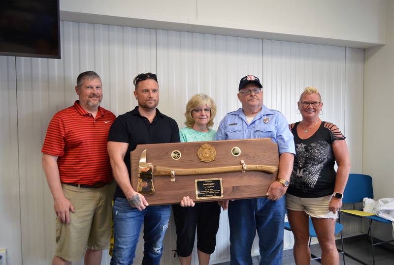 Forreston firefighter Jeff Burton, second from right, was presented with a golden ax by the fire department on June 12 in celebration of his 50th year of service. Burton poses with his wife and children here. From left to right are, Jeremey Burton, Justin Burton, Jean Burton, Burton and Jennifer Sarazin.