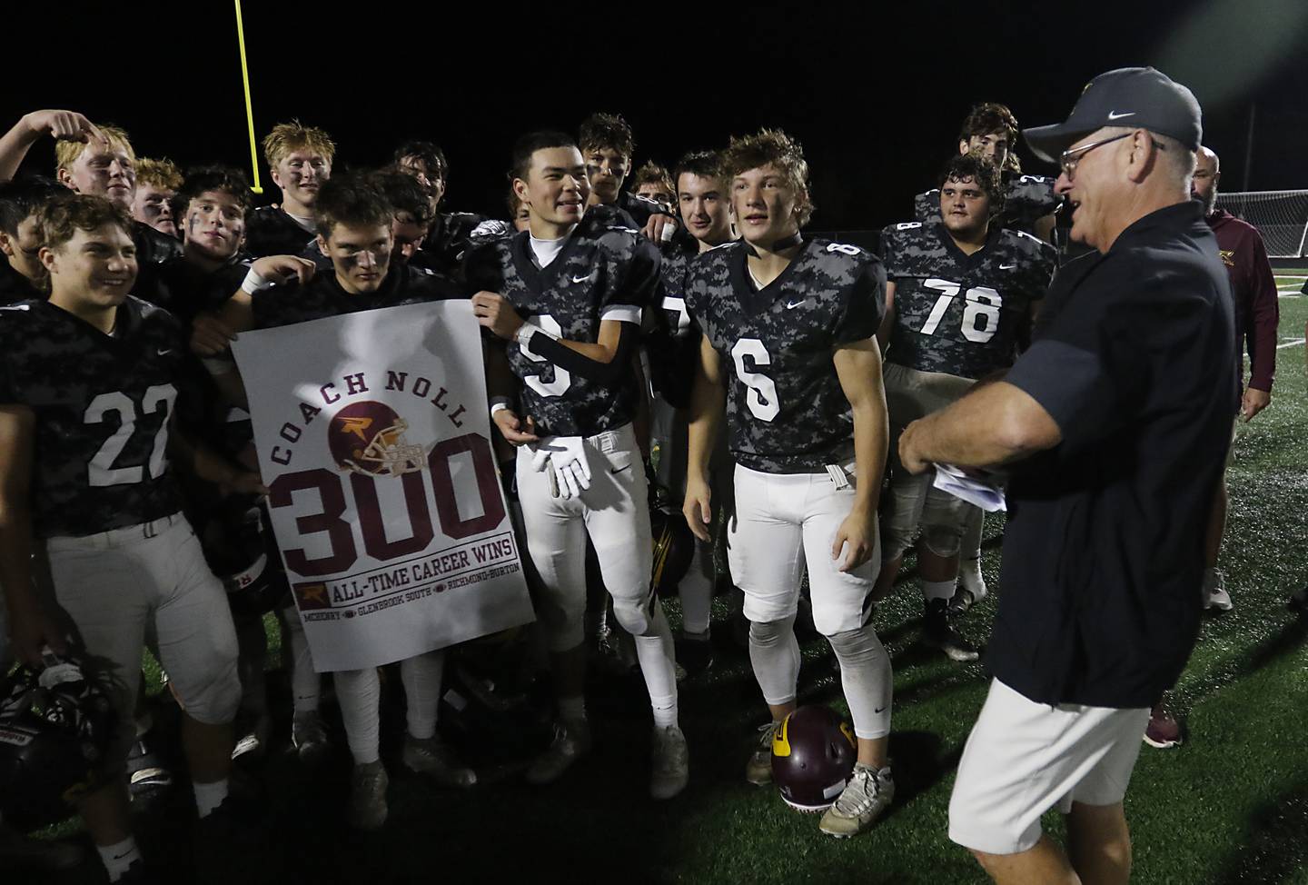 Richmond-Burton players hold a 300 win banner for Richmond-Burton Head Coach Mike Noll after Noll won his 300 game on Friday, Oct. 17, 2025, at Richmond-Burton High School in Richmond.