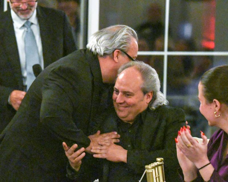 Rich Onesti, left, and his brother Ron Onesti, embrace after Rich introduced him at the St. Charles Area Chamber of Commerce Charlemagne Awards dinner, where Ron was a Charlemagne nominee on Friday May 1, 2026.