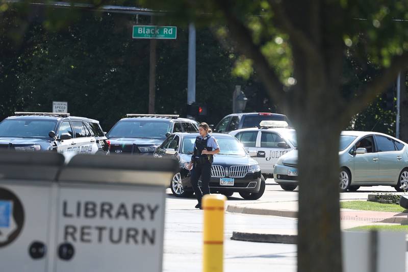 A Joliet police officer turns traffic away at the Black Road Branch Library after a bomb threat at that location on Thursday, Sept. 14, in Joliet.