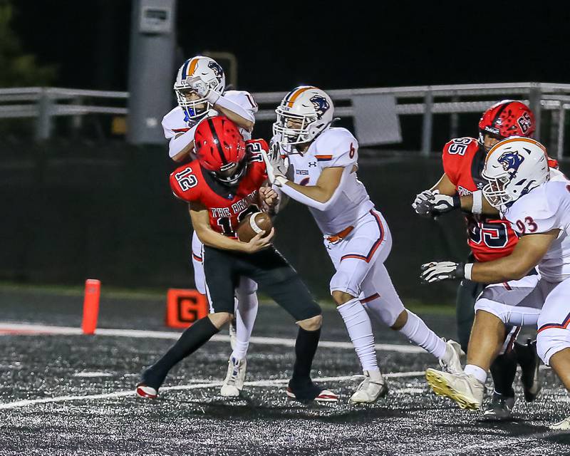 Oswego's Mariano Velasco (12) and Mikey Claycombe (6) sack Bolingbrook's Braden Andersen (12)during a football game between Oswego at Bolingbrook on Friday, Oct 4th, 2024  in Bolingbrook.