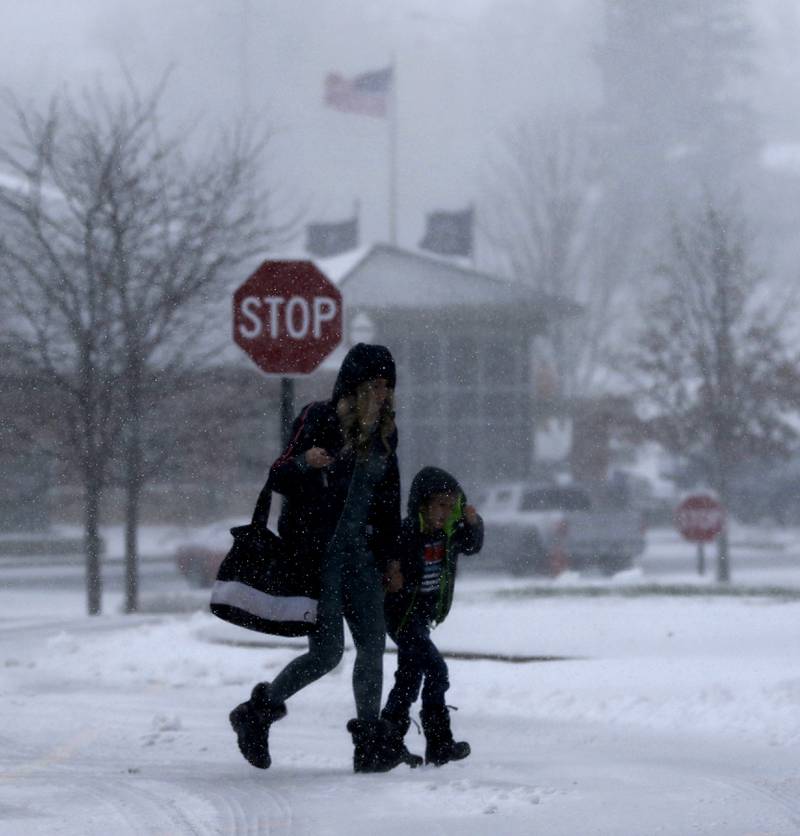 A mother and son trek through the snow Thursday, Nov. 21, 2024, in the parking lot of McHenry Recreation Center as winter weather makes its first appearance in McHenry County.