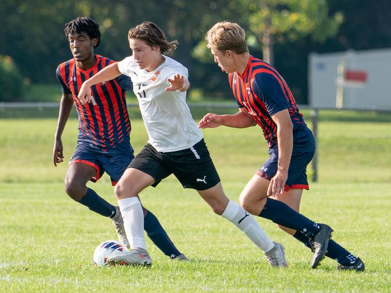 Wheaton Warrenville South's Robert Redlich (17) plays the ball between Oswego’s Thomas Marcoux (1) and Oswego’s Josh Nelson (11) during a soccer match at Oswego High School on Thursday, Aug 25, 2022.