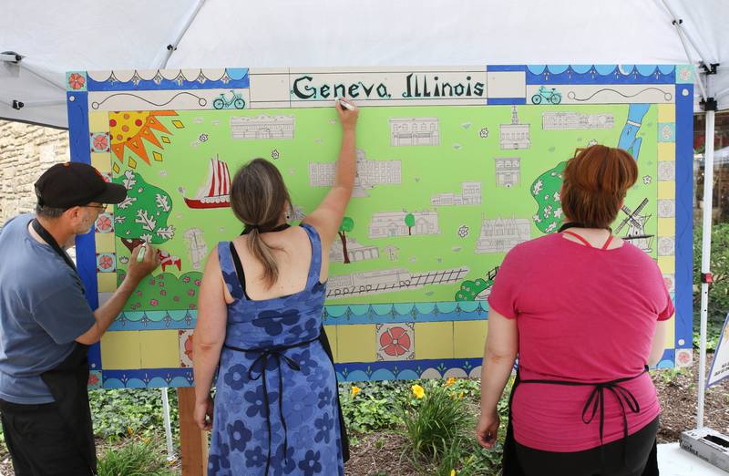 Mike Litwin, (left) Sandy Kresler and Kathryn Fredrickson, (right) all from Geneva, work on the Geneva Chamber of Commerce’s paint-by-number community art project Saturday, July 26, 2025, during at the Geneva Arts Fair on Third Street in Geneva.